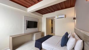 圣安德烈斯On Vacation Caribbean的卧室配有一张床,墙上配有电视。