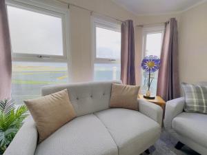 米勒姆LakeDistrict Caravan by Sleepy的带沙发、椅子和窗户的客厅