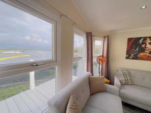 米勒姆LakeDistrict Caravan by Sleepy的带沙发和大窗户的客厅