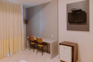 帕尔马斯拉戈大帕尔马酒店的配有桌椅和电视的客房