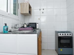 利伯维尔Résidence Céline的厨房配有水槽和炉灶