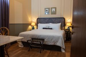 库塔伊西Communal Hotel Kutaisi的一间卧室配有一张床、一张桌子和两盏灯。