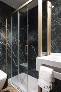 塞维利亚Luxury, Art and Deco apt para 4pax cerca de Plaza de España的一间带水槽和玻璃淋浴的浴室
