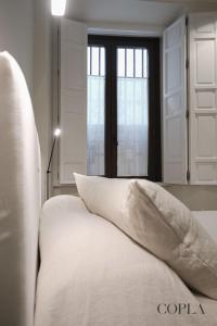 塞维利亚Luxury, Art and Deco apt para 4pax cerca de Plaza de España的窗前带枕头的白色床