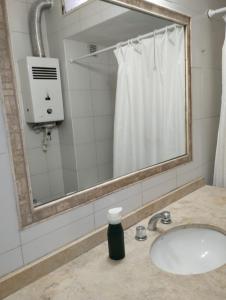 门多萨Houselyon的一间带水槽、镜子和淋浴的浴室