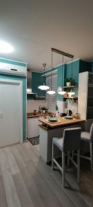 库尼奥L'alloggetto sul Corso的厨房配有绿色橱柜和桌椅