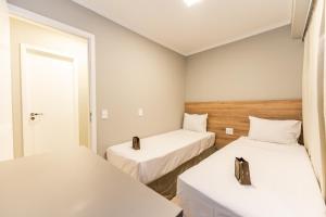 圣保罗Apartamentos Studio Allure Moema - Com recepção 24 horas的带两张床和镜子的客房