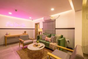 班加罗尔Olive Indiranagar 100ft Road - by Embassy Group的客厅配有绿色沙发和桌子