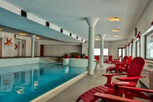 Kartalkaya卡尔塔酒店的一个带红色椅子和桌子的大型游泳池