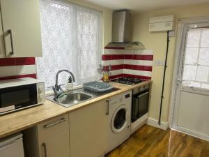 达格纳姆Experience Downing Road Dagenham 2 bedroom Apartment的厨房配有洗衣机和水槽