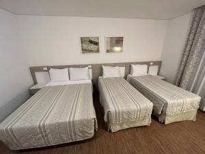 阿蒂巴亚Atibaia Residence Hotel & Resort的配有白色床单的酒店客房内的两张床