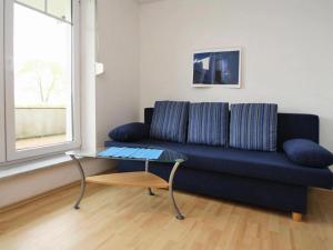 KummerowCottage on the Kummerower See, Kummerow的客厅配有蓝色的沙发和玻璃桌