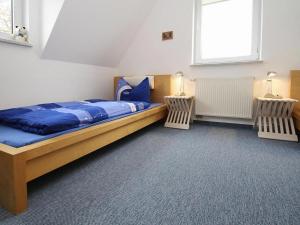 KummerowCottage on the Kummerower See, Kummerow的一间卧室配有一张带蓝色床单的床和一扇窗户。