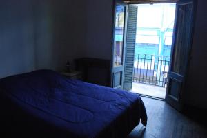 布宜诺斯艾利斯Lunfardo Boquense的一间卧室设有蓝色的床和一个阳台