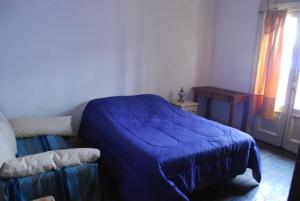 布宜诺斯艾利斯Lunfardo Boquense的一间卧室设有蓝色的床和窗户。