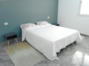 塔巴卡Villa Belle-Vue的卧室配有白色床单和白色大床