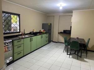帕拉马里博Osso fu mi ati (huis van mijn hart)的厨房配有绿色橱柜和桌椅