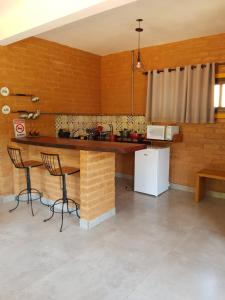 圣若昂-巴蒂斯塔-杜格罗里亚Pousada Fazenda Vitoria的厨房配有桌子、两把椅子和冰箱