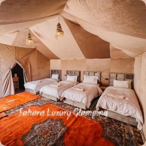 梅尔祖卡Sahara Luxury Glamping的帐篷内带四张床的房间