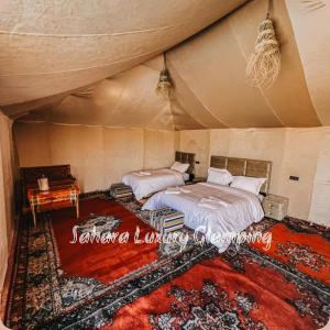 梅尔祖卡Sahara Luxury Glamping的一间帐篷内带两张床的卧室