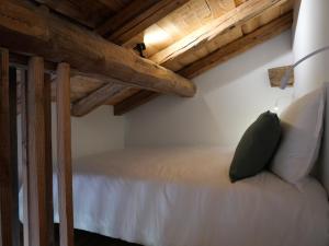 欧特吕斯La ferme d'Hauteluce - Chambre d'hôtes的木制天花板的客房内的一张床位
