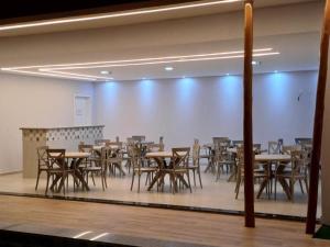 德尔米鲁戈韦亚Premium Hotel的一间设有桌椅和白色墙壁的用餐室