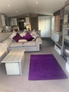 FlookburghHaven Lakeland 3 Bed Luxury Caravan的客厅配有沙发和紫色地毯