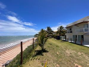 伊塔帕里卡岛维拉克鲁兹Casa, Frente Mar, Vera Cruz, Ilha de Itaparica, Tairu!的海滩边的围栏,有房子