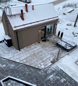 诺基亚Guesthouse with sauna & hot tub的一座有雪盖屋顶的小建筑