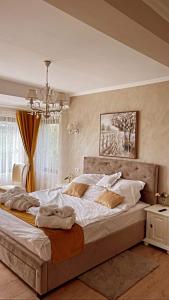 CoruşuSeara pe deal的一间卧室配有一张带白色床单的大床