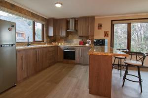 奥索尔诺mirabosque new aparments 2的厨房配有木制橱柜和带凳子的台面