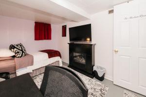 埃德蒙顿Quaint & Cozy Accommodation的客房设有床、壁炉和电视。