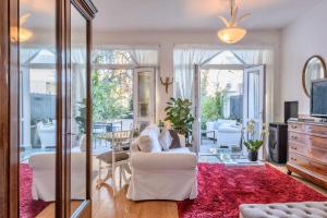 米兰阿依达公寓的客厅配有白色沙发和红色地毯。