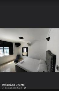 布卡拉曼加Residencia del Oriente的卧室配有白色的床和椅子