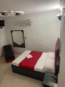 布卡拉曼加Residencia del Oriente的一间卧室配有一张床、镜子和椅子