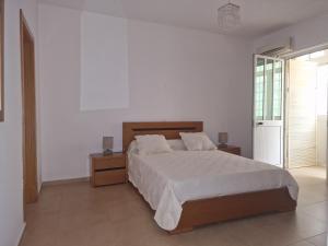 普拉亚Kaps Home Praia的一间卧室设有一张床和白色的墙壁