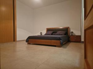普拉亚Kaps Home Praia的卧室配有1张床,铺有瓷砖地板。