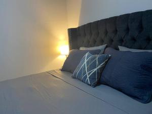 科潘省圣罗莎Céntrico Apartamento的一间卧室配有一张带蓝色枕头和一盏灯的床。