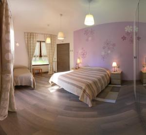 斯特雷萨加塔维奥拉公寓的一间卧室设有紫色的墙壁和一张大床