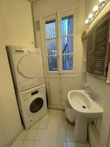 巴黎Le Cœur de l’Île Saint-Louis, you will love it!的一间带洗衣机和水槽的浴室