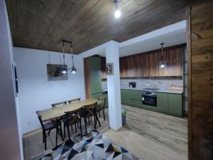 普里兹伦Villa Gjelbër的厨房以及带木桌和椅子的用餐室。