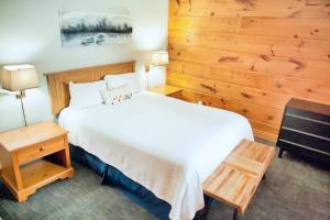 CallanderTerrace Suites的卧室配有白色的床和木墙