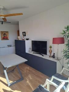 格拉纳达Gran apartamento familiar的客厅配有桌子和电视