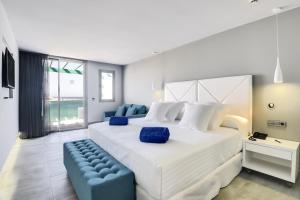 科斯塔特吉塞巴塞罗特吉塞海滩酒店 - 仅限成人的卧室配有一张白色大床和一张蓝色沙发。
