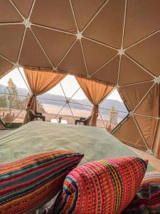 安达韦拉斯Pacucha Glamping的帐篷内的一张床位,享有沙漠美景