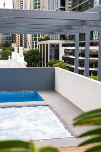 布里斯班Oaks Brisbane on Felix Suites的大楼顶部带游泳池的阳台