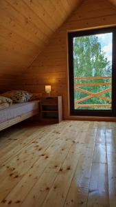 Potok ZłotyDomki Dębowe Wzgórze的小木屋内设有一间带大窗户的卧室