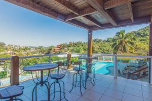 布希奥斯Pousada MAR João Fernandes的阳台设有酒吧凳,享有游泳池的景色。