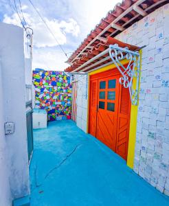 加利纽斯FLAT DA DANI Galinhos RN的一间设有色彩鲜艳的门的房间和一座建筑