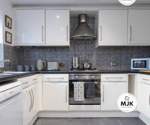 Ince-in-MakerfieldThe Westbourne Short-Stay的厨房配有白色橱柜和炉灶烤箱。